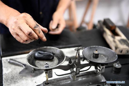 Wang Chunlin, a provincial-level inheritor of traditional handmade oil soot ink making in Anhui, started learning to make oil soot ink from his father at the age of 14. The oil soot inkstick made with traditional techniques from the soot of burnt tung oil or various other oils lines with smooth and bright luster. Along with the inkstone, brush, and paper, the inkstick is considered one of the