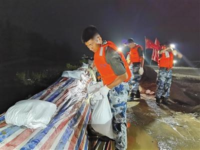 7月13日晚，江西省九江市江洲镇，檀磊和战友在加固堤坝。受访者供图